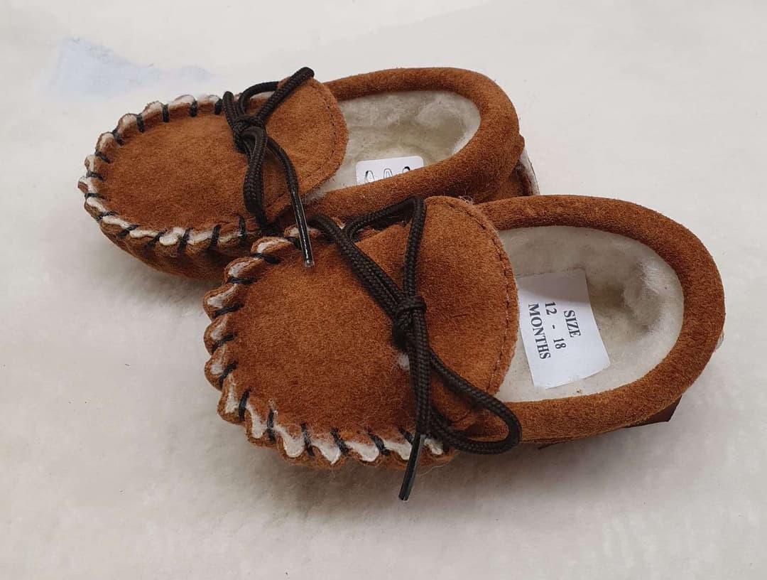A pair of baby slippers, with a sheo lace