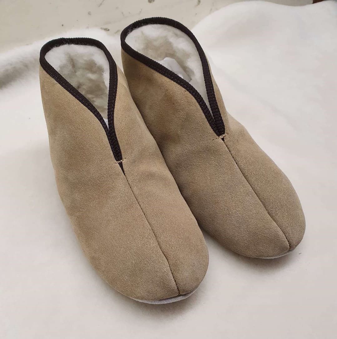 A pair of high-top slippers, with a black cuff